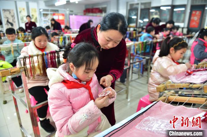 江西省級(jí)非遺豫章繡傳承人手把手指導(dǎo)小學(xué)生繡制2022年北京冬奧會(huì)吉祥物“冰墩墩”形象?！∮髟屏?攝