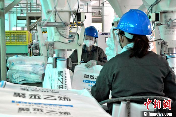 工人在生產(chǎn)線上包裝聚苯乙烯產(chǎn)品?！×趾霔v 攝