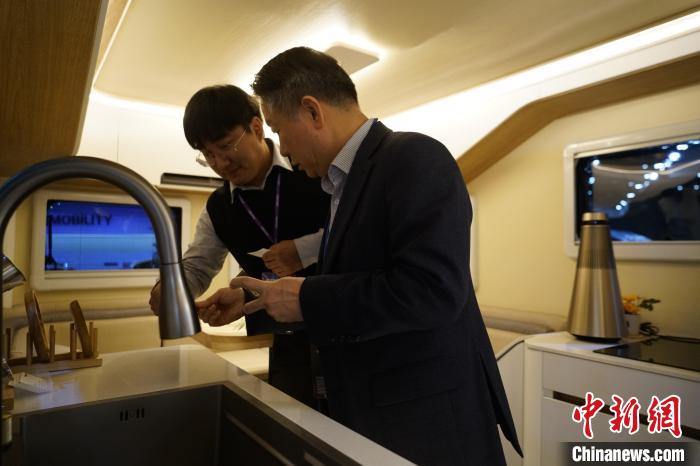 圖為參展商向觀眾介紹房車內(nèi)部設計?！⑿?攝