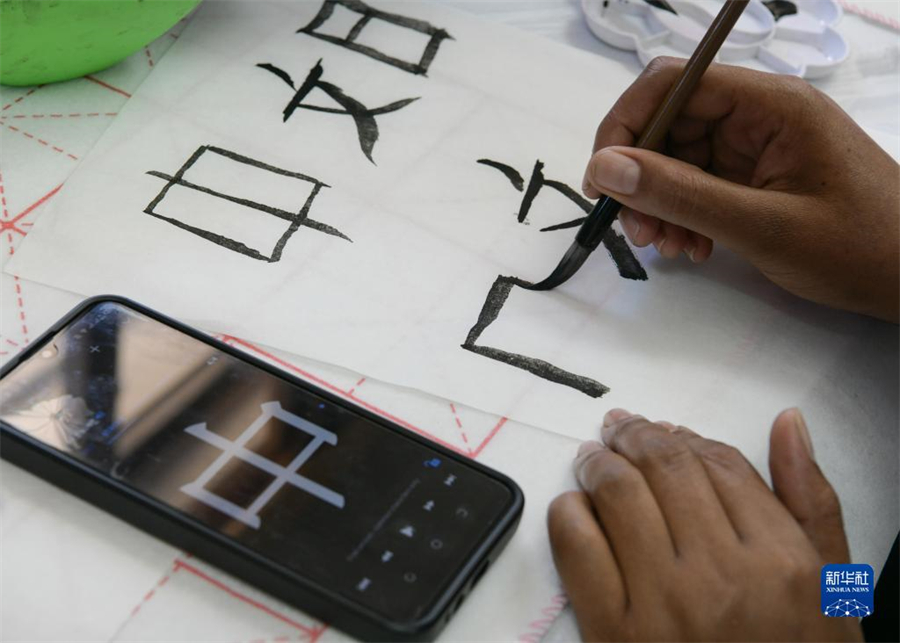 4月18日，肯尼亞學生在內(nèi)羅畢大學孔子學院舉辦的活動上寫毛筆字?？夏醽唭?nèi)羅畢大學孔子學院18日舉辦“中文，增進文明對話”主題活動，慶祝即將到來的第14個聯(lián)合國中文日?？夏醽唽W生參與互動，進行書法、剪紙、唱中文歌等活動。新華社記者 韓旭 攝