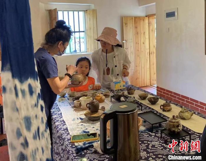 圖為：游客正在咨詢臺(tái)灣柴燒作品?！∪~秋云 攝