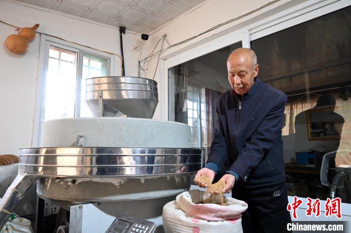 李家莊村民谷文朝重拾父輩的手藝，做起石磨面粉的營生?！〉杂鸺?攝