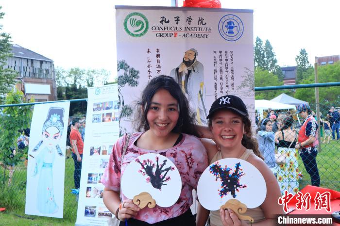 孩子們展示自己的吹墨畫團(tuán)扇作品?！◆斻肟鬃訉W(xué)院供圖