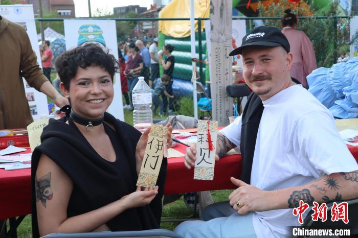 當(dāng)?shù)孛癖娫跐h字體驗工作坊展示自己手寫的中文名書簽?！◆斻肟鬃訉W(xué)院供圖