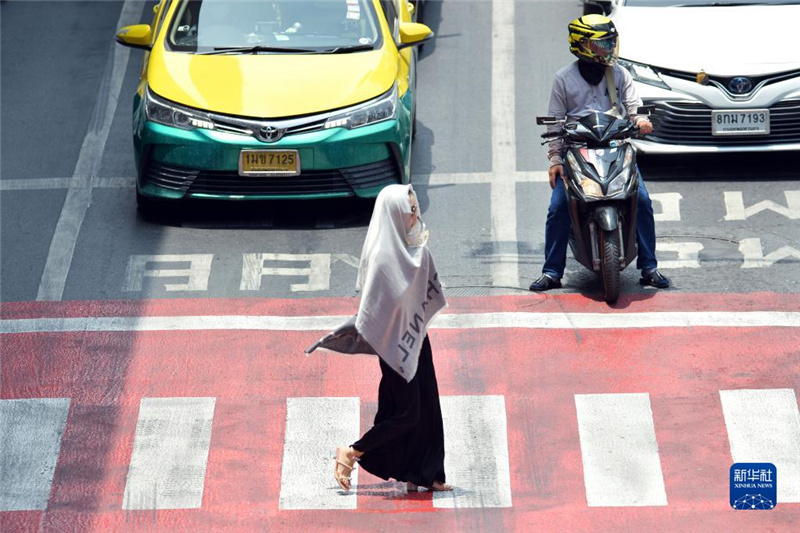 5月17日，行人在泰國曼谷街頭用圍巾遮陽。新華社發(fā)（拉亨攝）