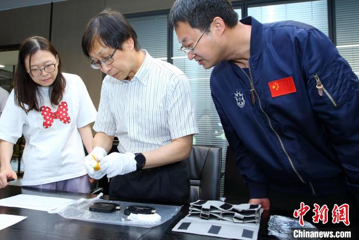 科研人員查看隨神舟十五號返回地面的空間科學實驗樣品?！≈锌圃嚎臻g應(yīng)用中心 供圖