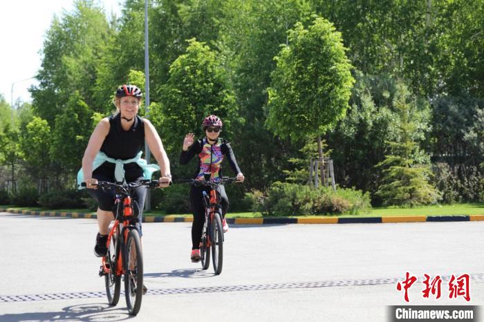 亞信副秘書長遲方(右一)與聯(lián)合國駐哈協(xié)調(diào)員在騎行活動中。　亞信秘書處供圖