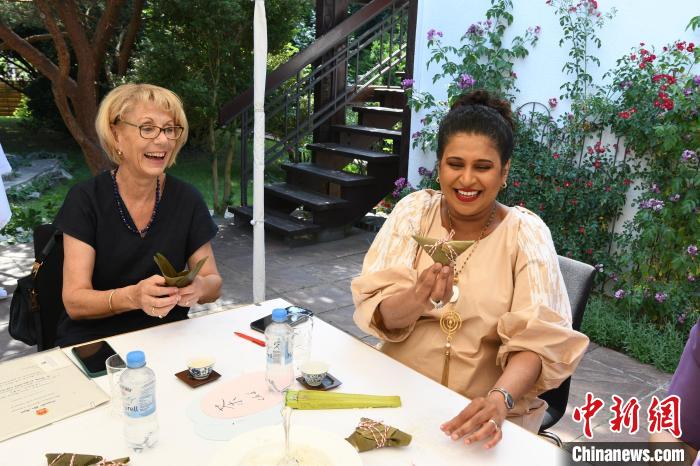 圖為嘉賓展示包粽子成果?！“亓种袊幕行墓﹫D。