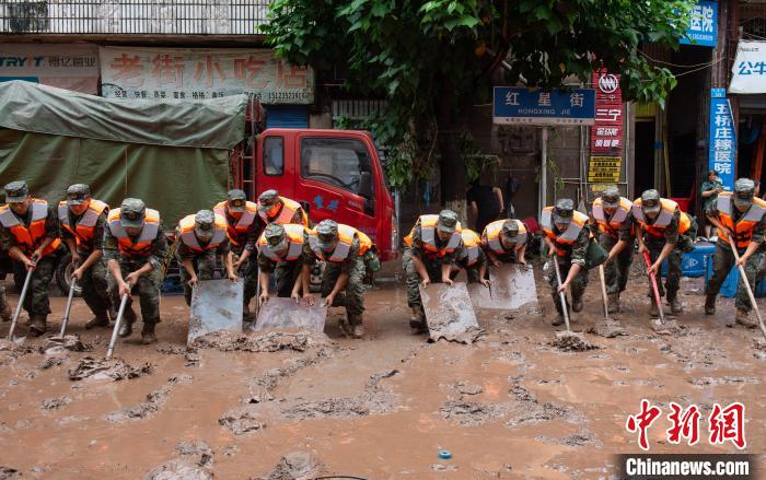 7月4日，萬州區(qū)五橋街道，武警官兵清理街道上的淤泥?！∪矫宪?攝