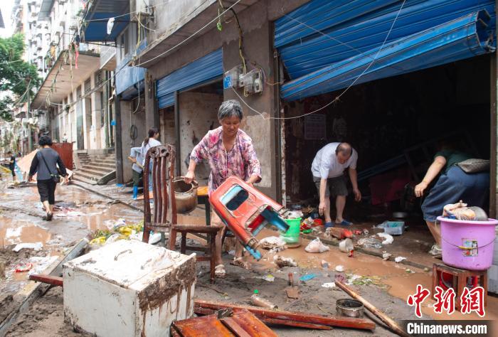 7月4日，萬州區(qū)五橋街道，洪水退去后，居民搶救生活物資?！∪矫宪?攝