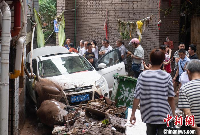 7月4日，萬州區(qū)五橋街道，居民救援受困的私家車。　冉孟軍 攝