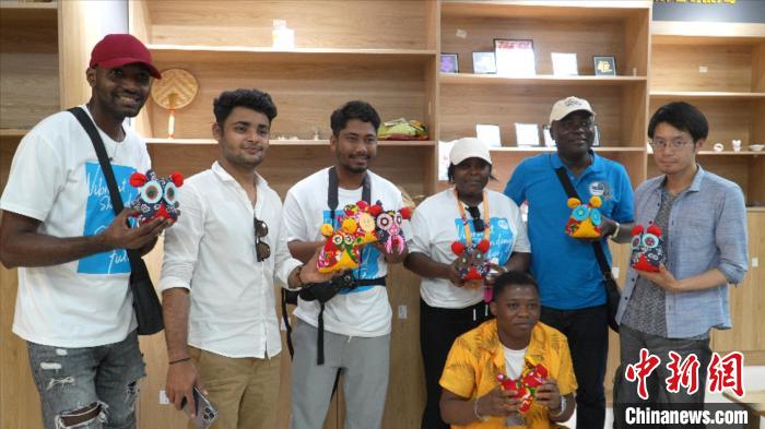 圖為國際青年代表展示親手制作的東營非遺黃河口布偶 ?！↓R魯 攝