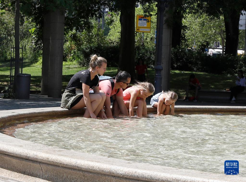 7月8日，人們在德國法蘭克福的一處噴泉玩水。近日，德國法蘭克福逐漸迎來暑熱天氣。新華社記者 張帆 攝