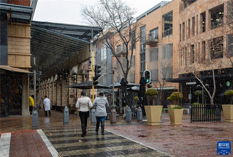 7月10日，在南非約翰內(nèi)斯堡一處商業(yè)區(qū)，人們在雪中行走。新華社記者 張譽(yù)東 攝