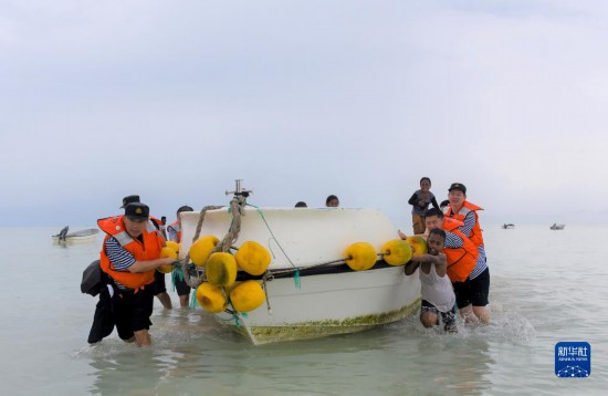 7月21日，中國海軍“和平方舟”號(hào)醫(yī)院船醫(yī)護(hù)人員涉水登島，前往基里巴斯一診療點(diǎn)。新華社記者 黎云 攝