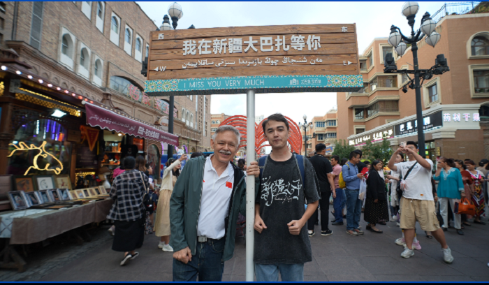 潘維廉和維吾爾族青年伊木蘭“打卡”大巴扎。主辦方供圖