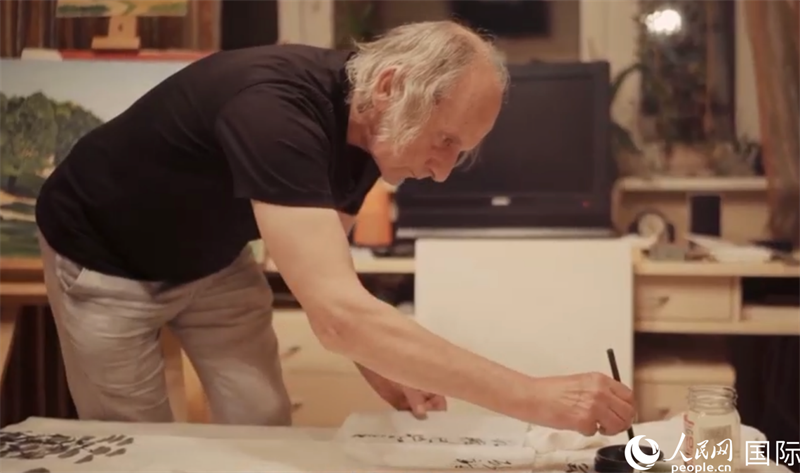 伊戈爾·布爾東諾夫在畫作上題詞。人民網(wǎng)記者 馬天翼攝