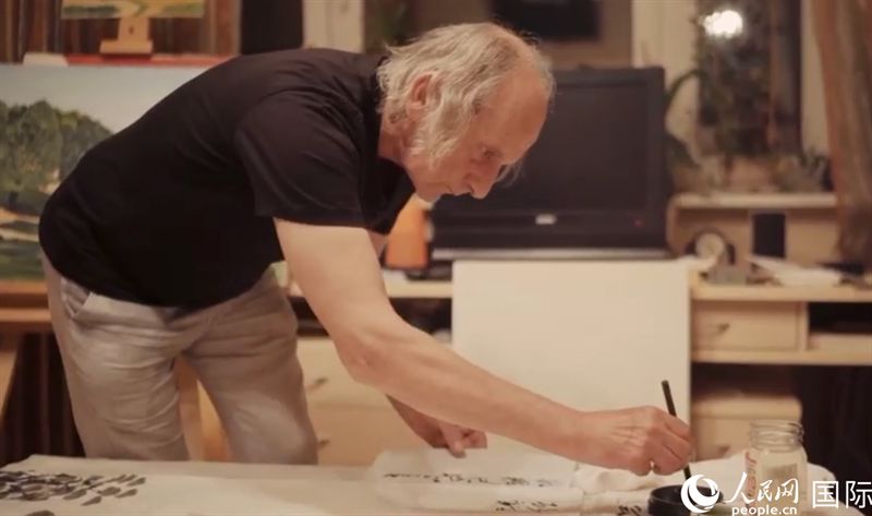 伊戈爾·布爾東諾夫在畫作上題詞。人民網(wǎng)記者 馬天翼攝