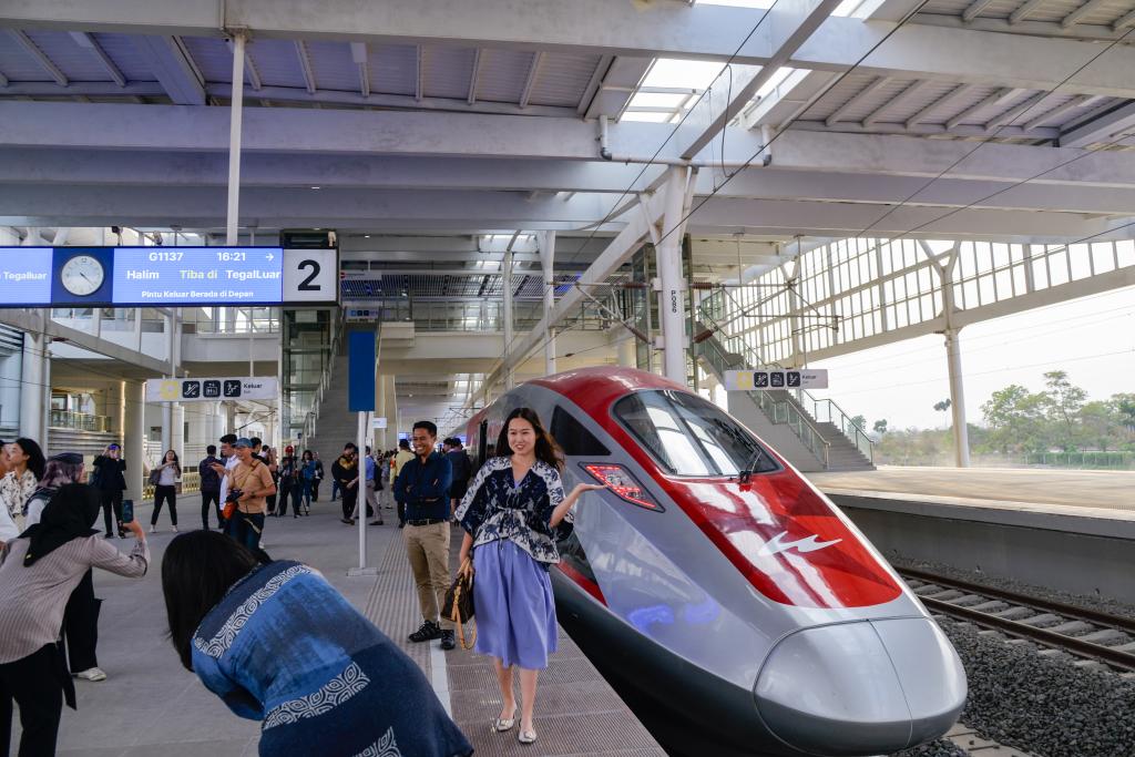 10月17日，在印度尼西亞萬隆德卡魯爾站，乘客在站臺上和雅萬高鐵高速動車組列車合影。