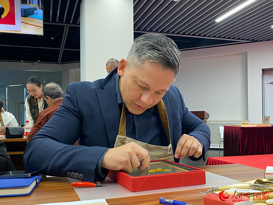 2023“一帶一路”媒體合作論壇聯(lián)合采訪團團員，親身體驗景泰藍工藝。人民網(wǎng)記者 于洋攝