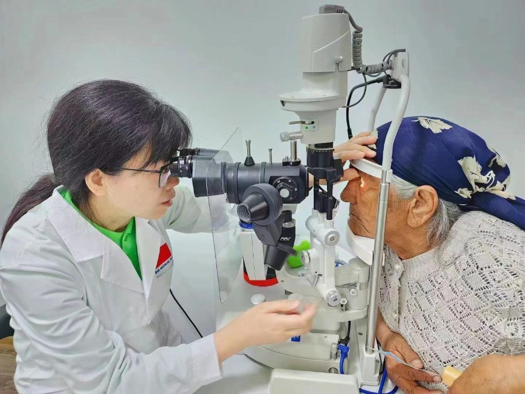 北京大學(xué)人民醫(yī)院眼科醫(yī)生鮑永珍正在為中亞白內(nèi)障患者進(jìn)行眼部檢查。（北京大學(xué)人民醫(yī)院供圖）