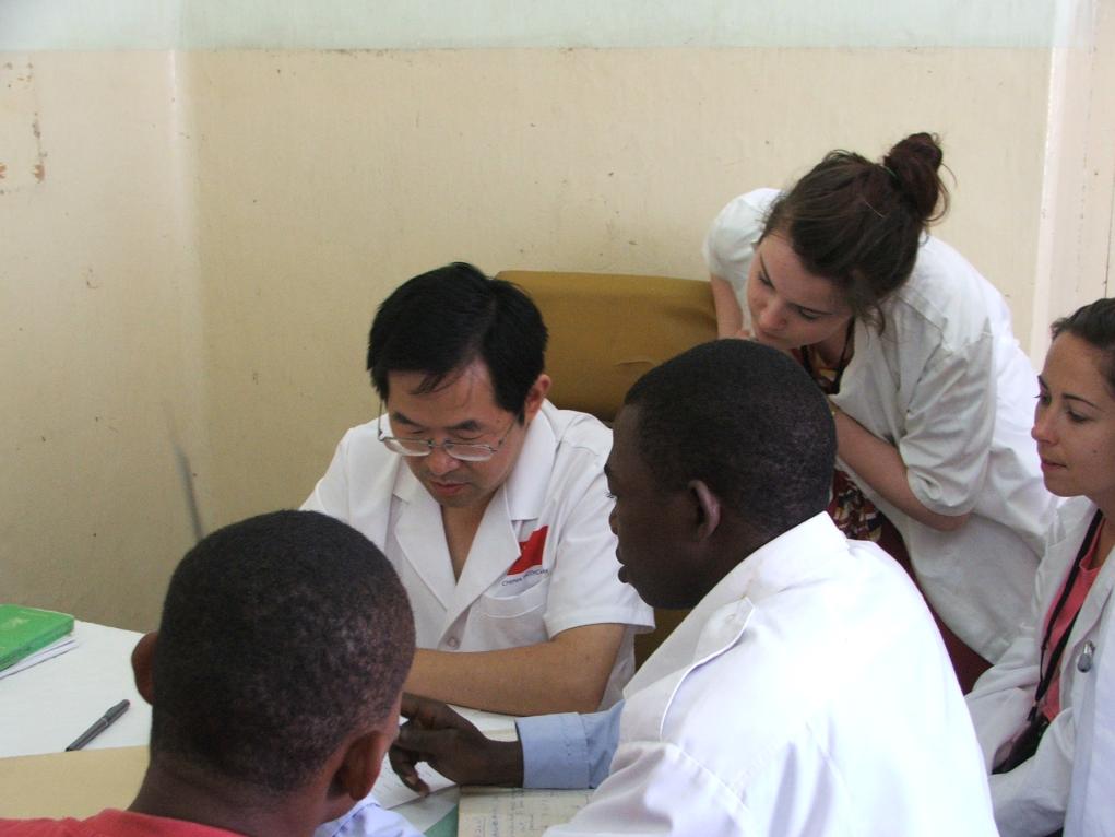 2011年7月22日，在坦桑尼亞桑給巴爾納茲莫加醫(yī)院外科門診，中國(guó)第24批援桑給巴爾醫(yī)療隊(duì)隊(duì)長(zhǎng)盧建林為當(dāng)?shù)鼗颊咴\治并帶教實(shí)習(xí)生。新華社發(fā)（國(guó)家衛(wèi)生健康委供圖）
