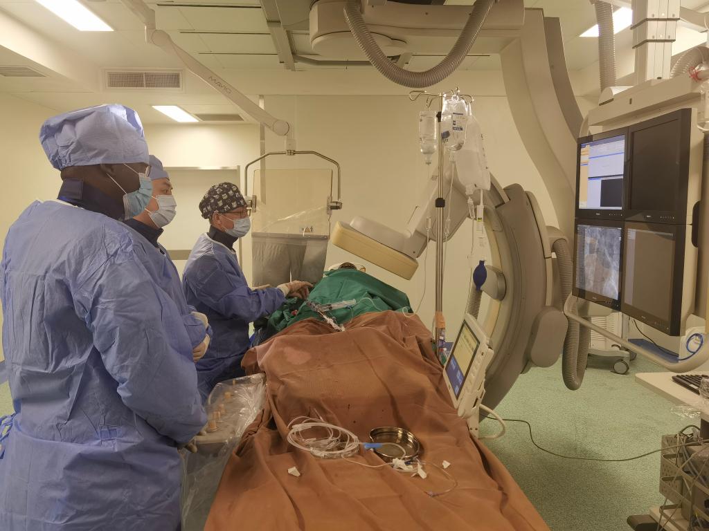 中國(guó)第29批援幾內(nèi)亞醫(yī)療隊(duì)隊(duì)員、首都醫(yī)科大學(xué)附屬北京天壇醫(yī)院心內(nèi)科副主任醫(yī)師王汝朋（右一）正在給患者做手術(shù)。（北京天壇醫(yī)院供圖）