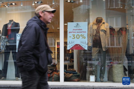   10月31日，一名男子從比利時(shí)布魯塞爾一家貼有打折信息的店鋪前走過。新華社記者 趙丁喆 攝