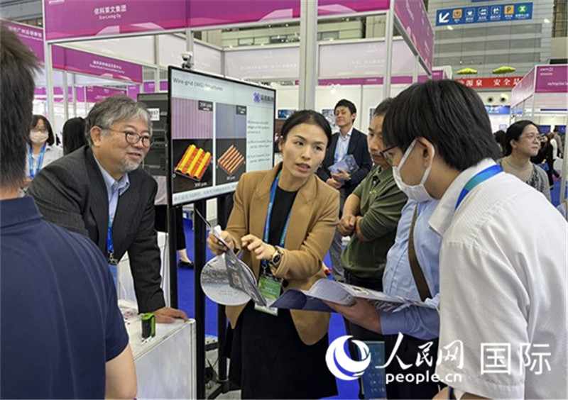 工作人員向參觀者介紹超級(jí)噴墨技術(shù)。（人民網(wǎng)記者 陳思攝）