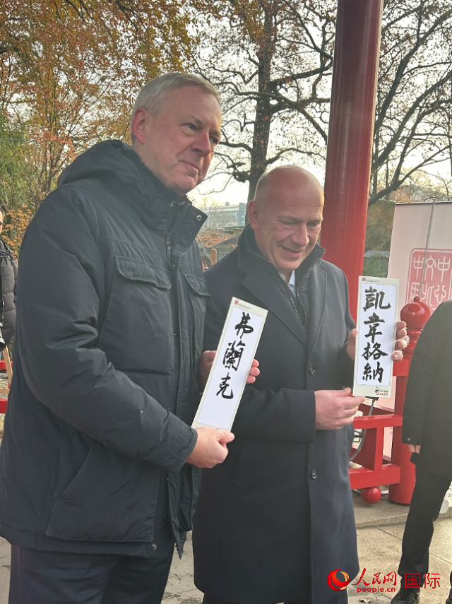 柏林市長韋格納（右）、動物園監(jiān)事會主席布魯克曼（左）手持中國文化中心工作人員現(xiàn)場手書的中文名字。人民網(wǎng)記者 徐馨攝