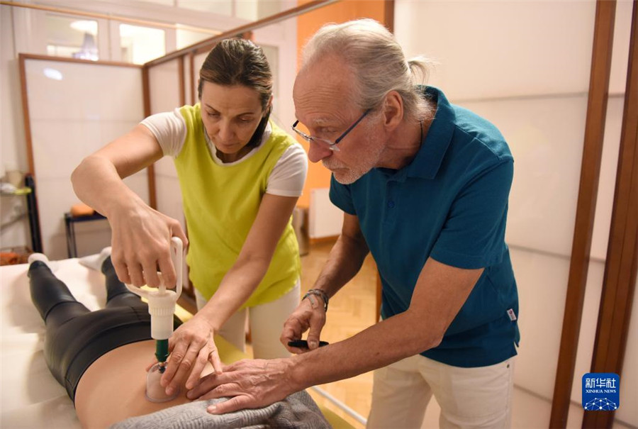 12月12日，在奧地利維也納，科格勒醫(yī)生（右）和助手在為病人進行拔罐治療。新華社記者 賀燦鈴 攝