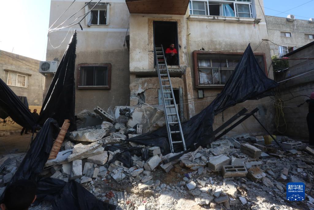 12月17日，在約旦河西岸城市圖勒凱爾姆附近的一處難民營，人們查看在沖突中損毀的房屋。新華社發(fā)（尼達(dá)爾·艾仕塔耶?dāng)z）