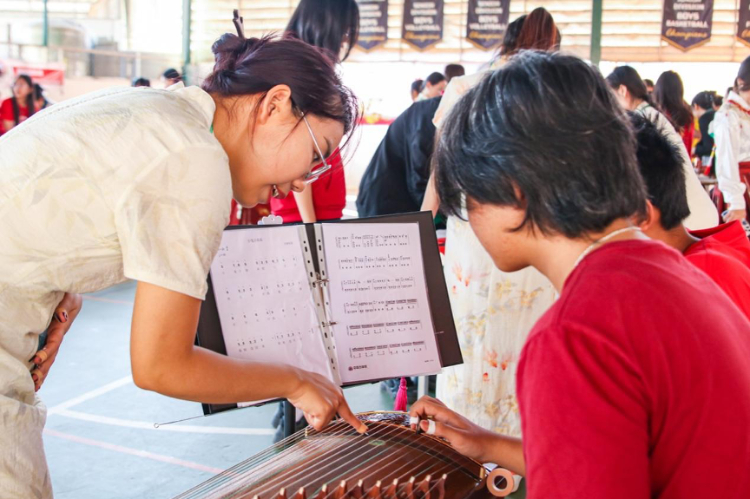 志愿者教師指導(dǎo)學(xué)生彈奏古箏?；顒?dòng)主辦方供圖