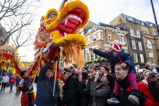 2月11日，人們在英國倫敦的新春巡游活動中觀看舞龍表演。新華社發(fā)（史蒂芬·程攝）
