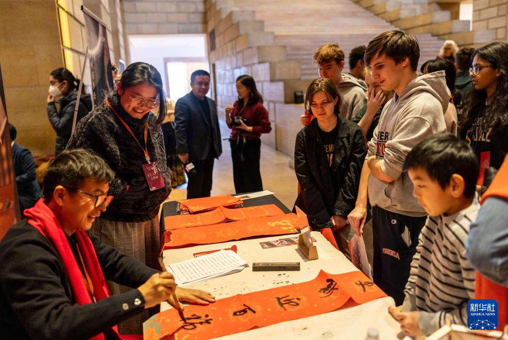 2月11日，書法家在美國(guó)費(fèi)城藝術(shù)博物館舉行的龍年迎新春活動(dòng)上為參觀者書寫對(duì)聯(lián)。新華社發(fā)（周煥新攝）