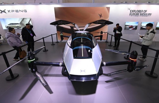 2023年12月1日，在鏈博會智能汽車鏈展區(qū)小鵬汽車展臺，參觀者觀看一臺智能飛行器。新華社記者蔡湘鑫攝