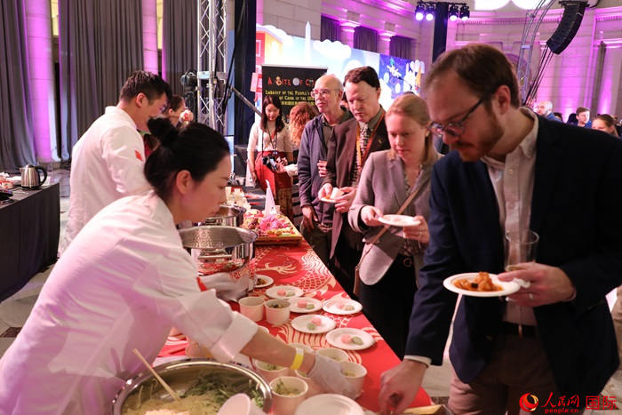 當(dāng)?shù)貢r間3月7日晚，華盛頓聯(lián)合車站廣場舉行駐美使團“使館主廚挑戰(zhàn)賽”。圖為當(dāng)?shù)孛癖娫谥袊古_前體驗中國美食。人民網(wǎng)記者 李志偉攝