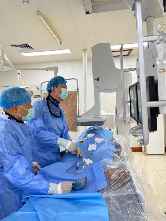 李凱教授（右）和劉海濤教授（左）為患者行TACE手術(shù)。中國駐老撾大使館供圖