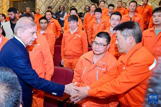 4月1日，在巴基斯坦西北部開伯爾-普什圖省達蘇，巴基斯坦總理夏巴茲（左）同達蘇水電站項目中方員工握手。新華社發(fā)（巴基斯坦新聞與廣播部下轄媒體信息部門供圖）