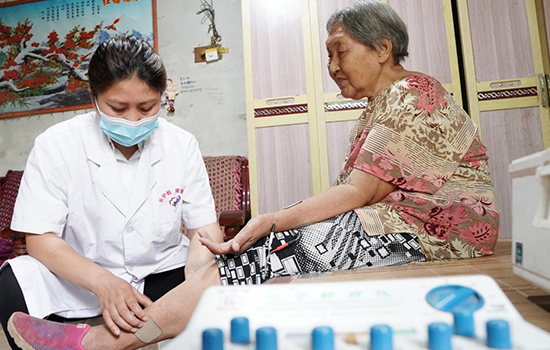 護理團隊醫(yī)生為老人進行低頻功能康復(fù)。陳佳兵攝