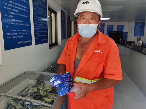 1環(huán)衛(wèi)工倪建宏小憩后，為還同事帶去冷飲。人民網(wǎng)記者王繼亮攝