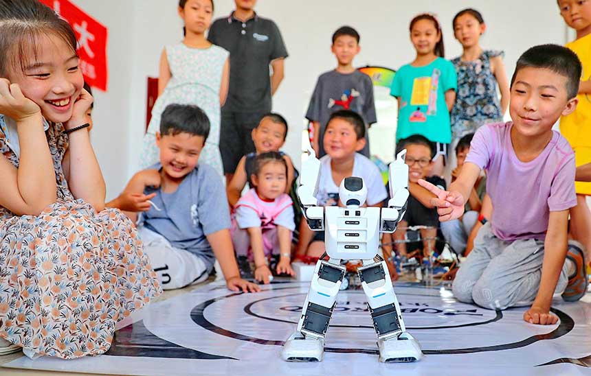 2022年7月19日，河北省秦皇島市海港區(qū)白塔嶺街道秦皇半島第二社區(qū)內(nèi)，小朋友正在觀看“機器人跳舞”。 曹建雄攝