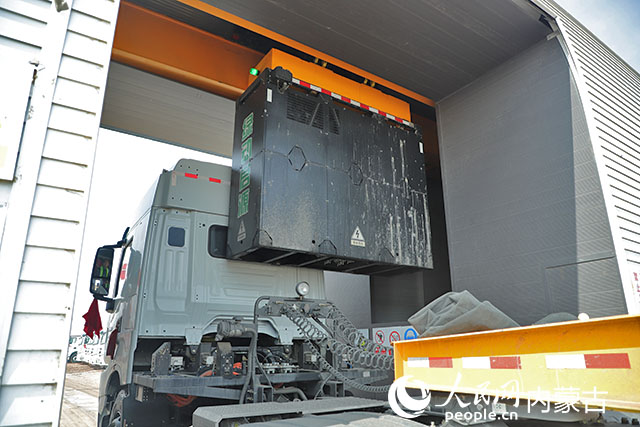 萬利新能源數(shù)字陸港里，正在充換電站進行換電的重卡。人民網(wǎng)記者 趙夢月攝