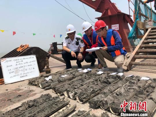 圖為勘察設(shè)計(jì)人員與海事局工作人員查看巖芯情況?！∥赫?攝