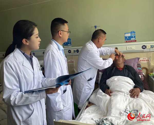 董光明（左三）帶領(lǐng)醫(yī)生對患者進(jìn)行術(shù)前檢查。人民網(wǎng)記者 杜燕飛攝