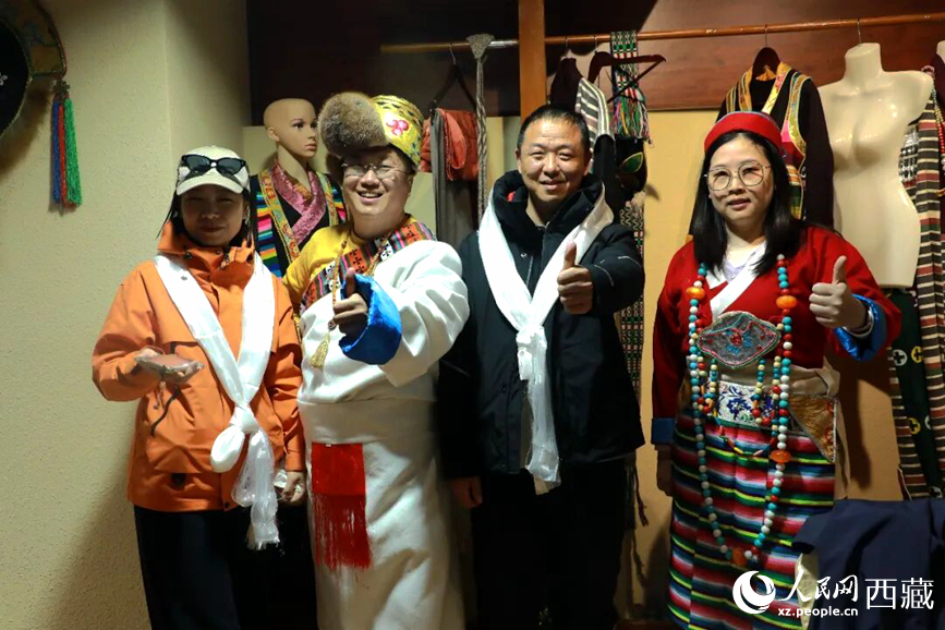 游客在扎西曲登社區(qū)體驗藏族服飾文化。大家身著色彩鮮艷的藏裝，佩戴特色飾品，臉上洋溢著喜悅的笑容。人民網(wǎng)記者 吳雨仁攝