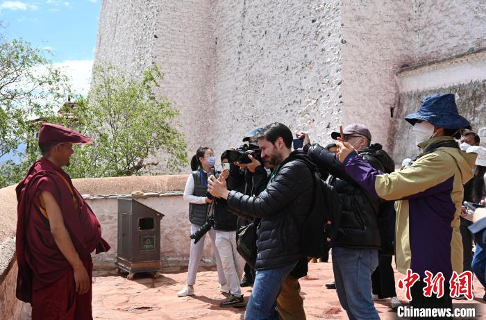 圖為中外媒體拍攝朝拜布達(dá)拉宮的僧人?！≮w朗 攝