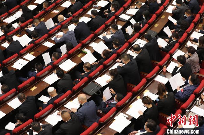 圖為會議現(xiàn)場，參會代表正在聽取政府工作報告?！∑钤鲚?攝