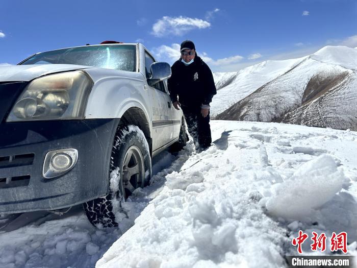 圖為生態(tài)管護人員準備在雪地推車?！《“瓦_杰 攝