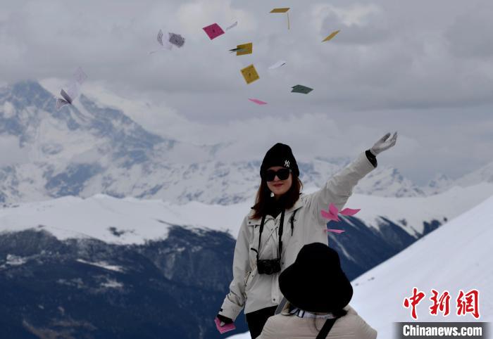 圖為5月14日，游客在西藏林芝色季拉山觀景臺拋灑“隆達”(風馬旗，藏族民眾的一種祈福方式)?！±盍?攝
